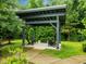 View of the outdoor covered lounge area with seating nestled in a lush green space at 515 N Churton St # 203, Hillsborough, NC 27278