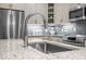 Close-up of the kitchen island with granite countertops and stainless steel sink and fixtures at 515 N Churton St # 203, Hillsborough, NC 27278