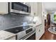 Modern kitchen with stainless steel appliances, granite countertops, and light gray backsplash tiles at 515 N Churton St # 203, Hillsborough, NC 27278