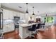 Open-concept living space with kitchen island, dining area, and living room, featuring hardwood floors at 515 N Churton St # 203, Hillsborough, NC 27278