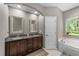 Bathroom boasting double vanity with granite countertop and soaking tub at 5321 Cambridgeshire Loop, Cary, NC 27519