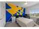 Bright bedroom featuring geometrically painted accent wall and a ceiling fan at 5321 Cambridgeshire Loop, Cary, NC 27519