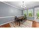 Bright dining room features hardwood floors, elegant chandelier, and views of the back yard at 5321 Cambridgeshire Loop, Cary, NC 27519