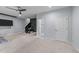 Spacious living room with carpet flooring, ceiling fan, adjacent stairway, and entry to a full bathroom at 5321 Cambridgeshire Loop, Cary, NC 27519