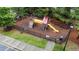 Aerial view of playground with swings, slide and climbing area surrounded by a fence and mature trees at 5321 Cambridgeshire Loop, Cary, NC 27519