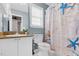 Bright bathroom with a vanity, toilet, and a shower curtain with a beach theme at 5512 Grand Traverse Dr, Raleigh, NC 27604