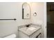 Bathroom vanity featuring a granite countertop, black hardware and an arched mirror at 5576 Foothills Ct, Snow Camp, NC 27349