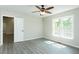 This bright bedroom has a ceiling fan, hardwood floors, and a white door at 5576 Foothills Ct, Snow Camp, NC 27349
