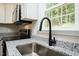Close up on the kitchen sink featuring stainless steel appliances and a large window at 5576 Foothills Ct, Snow Camp, NC 27349