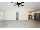 Open-concept living area with sleek gray floors, modern lighting, and a view of the kitchen at 5576 Foothills Ct, Snow Camp, NC 27349