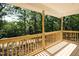 Inviting porch with wood railings and a serene view of the surrounding greenery at 5576 Foothills Ct, Snow Camp, NC 27349