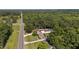 Sprawling property featuring multiple brick buildings, long driveways, a pond, and lush surrounding trees at 5820 Wake Forest Hwy, Durham, NC 27703