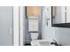 A bathroom with a toilet, sink, and storage cabinets in the light blue walled room at 5820 Wake Forest Hwy, Durham, NC 27703