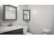 A well-lit bathroom featuring a modern sink, framed mirror, and toilet against cool gray walls at 5820 Wake Forest Hwy, Durham, NC 27703