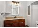 Bathroom features wood cabinets, granite countertop, illuminated mirror, neutral wall color, and copper fixtures at 5820 Wake Forest Hwy, Durham, NC 27703