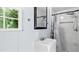 A bathroom featuring a white sink and a rainfall shower behind a curtain with a window to the left at 5820 Wake Forest Hwy, Durham, NC 27703
