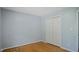 Bedroom featuring hardwood floors, closet, a light gray wall color, and neutral trim at 5820 Wake Forest Hwy, Durham, NC 27703