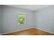 Bedroom featuring hardwood floors, a light gray wall color, and neutral window trim at 5820 Wake Forest Hwy, Durham, NC 27703