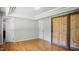 Bedroom featuring hardwood floors, closet with sliding barn door, and ample natural light at 5820 Wake Forest Hwy, Durham, NC 27703