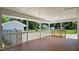 Wide covered patio boasts wood floor, painted brick, and an open-air design, blending indoor/outdoor living at 5820 Wake Forest Hwy, Durham, NC 27703