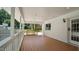 Wide covered patio boasts wood floor, painted brick, and an open-air design, blending indoor/outdoor living at 5820 Wake Forest Hwy, Durham, NC 27703