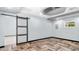 A light flex room with herringbone floors, recessed lighting, and a sliding door to the left at 5820 Wake Forest Hwy, Durham, NC 27703