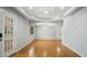 Bright living room showcasing tray ceiling, chandelier, hardwood floors, and abundant natural light through a large window at 5820 Wake Forest Hwy, Durham, NC 27703