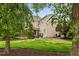 Backyard lawn with brick home, wooden deck, and mature trees with mulch beds and green lawn at 6005 Carlyle Dr, Raleigh, NC 27614