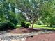 Backyard stone patio with lush landscaping and mature trees in a beautiful, wooded setting at 6005 Carlyle Dr, Raleigh, NC 27614