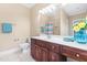 Bathroom with dark wood vanity, solid surface counter, large mirror, and tile flooring for easy cleaning at 6005 Carlyle Dr, Raleigh, NC 27614