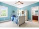Charming blue bedroom with white trim, carpet, and a classic bed frame, complemented by natural light at 6005 Carlyle Dr, Raleigh, NC 27614