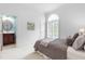 Comfortable bedroom with a glimpse into the attached bathroom, featuring an arched window with shutters at 6005 Carlyle Dr, Raleigh, NC 27614