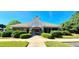 View of clubhouse entrance featuring stone accents, manicured shrubs, and a well-maintained lawn at 6005 Carlyle Dr, Raleigh, NC 27614