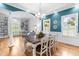 A dining room featuring hardwood floors and a large table, along with a view of the built-in bookshelf at 6005 Carlyle Dr, Raleigh, NC 27614