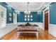 A well-lit dining room with hardwood floors, a table with bench, and an elegant chandelier at 6005 Carlyle Dr, Raleigh, NC 27614