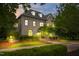 Elegant brick home with warm interior lighting and beautifully landscaped grounds, creating a welcoming ambiance in the evening at 6005 Carlyle Dr, Raleigh, NC 27614