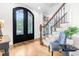 Elegant foyer with ornate iron double doors, hardwood floors, and staircase with wood railing and iron spindles at 6005 Carlyle Dr, Raleigh, NC 27614