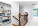 Hallway showcasing the hardwood staircase and built-in shelving at 6005 Carlyle Dr, Raleigh, NC 27614
