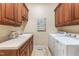 Functional laundry room with washer, dryer, sink, countertop, and cherry cabinetry providing ample storage at 6005 Carlyle Dr, Raleigh, NC 27614