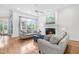 Cozy living room with hardwood floors, fireplace, and a large window overlooking the backyard at 6005 Carlyle Dr, Raleigh, NC 27614