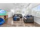 Bright living room with gray sofas, wood floors, ceiling fan, and natural light from shuttered windows at 6005 Carlyle Dr, Raleigh, NC 27614