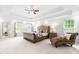 A spacious primary bedroom offers natural light, a sitting area, and decorative tray ceilings at 6005 Carlyle Dr, Raleigh, NC 27614