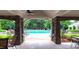 View through stone archway to a community swimming pool with lounge chairs and greenery at 6005 Carlyle Dr, Raleigh, NC 27614