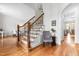 Elegant staircase with hardwood treads, white risers, wood railing and iron spindles with an entry to another room at 6005 Carlyle Dr, Raleigh, NC 27614
