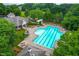Aerial view of the community swimming pool with lounge chairs and a pergola in a wooded, landscaped setting at 6005 Carlyle Dr, Raleigh, NC 27614