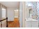 Hallway featuring wood floors, white trim, and a view into a colorful bathroom at 604 Eden Ln, Chapel Hill, NC 27517