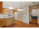 Kitchen featuring white appliances, wood cabinets and brick floors at 604 Eden Ln, Chapel Hill, NC 27517