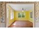 Bright sunroom featuring yellow walls, large windows, and a ceiling fan at 604 Eden Ln, Chapel Hill, NC 27517