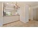 Bright dining area featuring a decorative chandelier, half wall to the kitchen, and access to additional living spaces at 615 Carlton Commons Ln, Cary, NC 27519