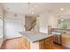 Spacious kitchen featuring an island with seating, stainless steel appliances, hardwood flooring, and easy access to other areas at 615 Carlton Commons Ln, Cary, NC 27519